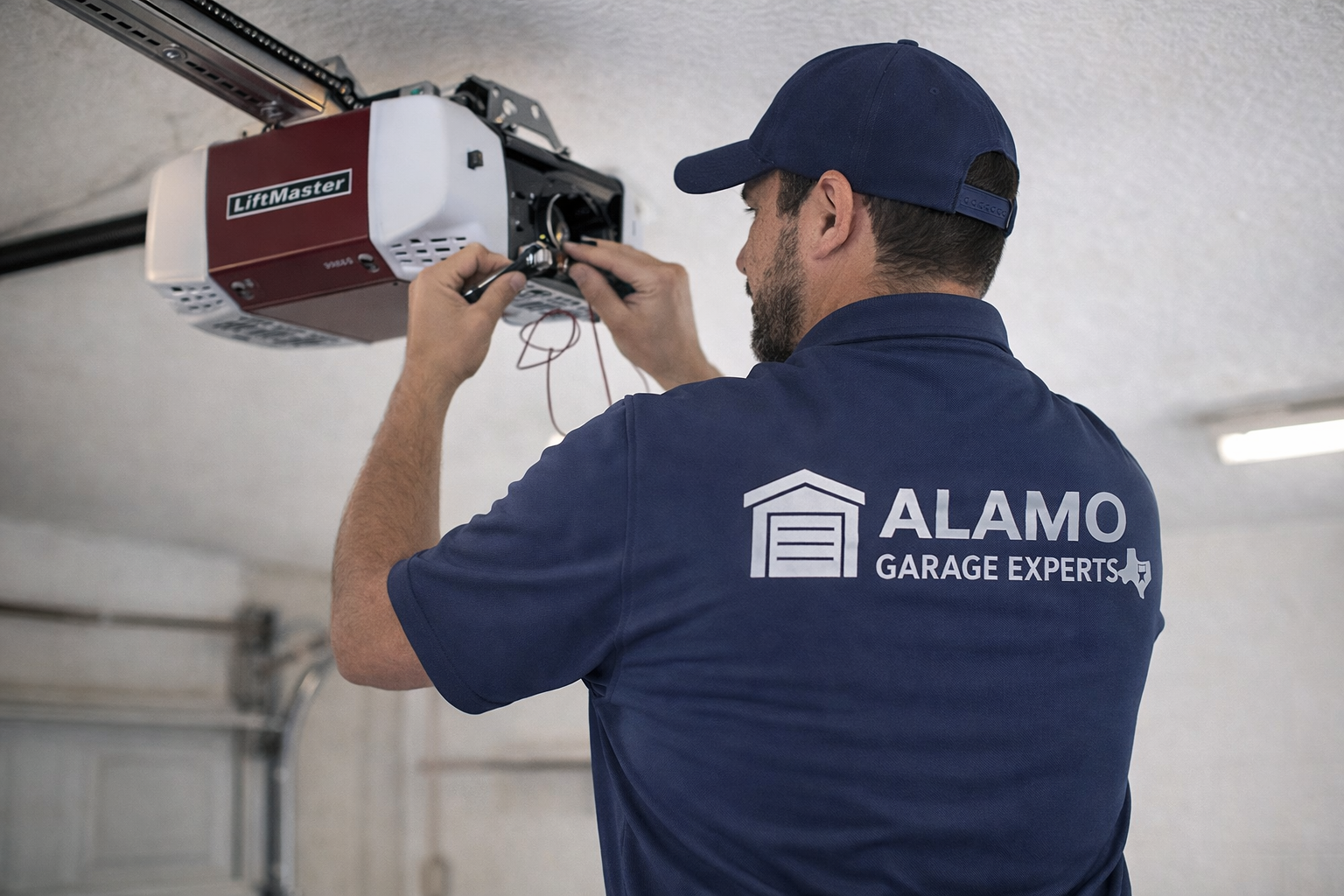 Garage door liftmaster opener repair by Alamo Garage Experts Technician in blue uniform.
